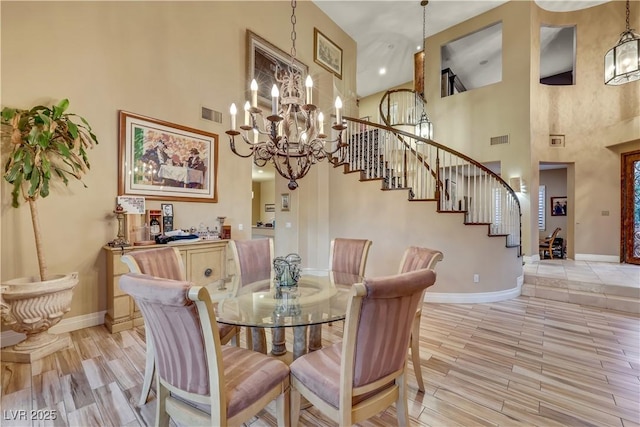 dining space featuring light wood-style floors, baseboards, stairs, and visible vents