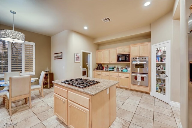 kitchen featuring light tile patterned floors, light brown cabinets, visible vents, a center island, and black appliances