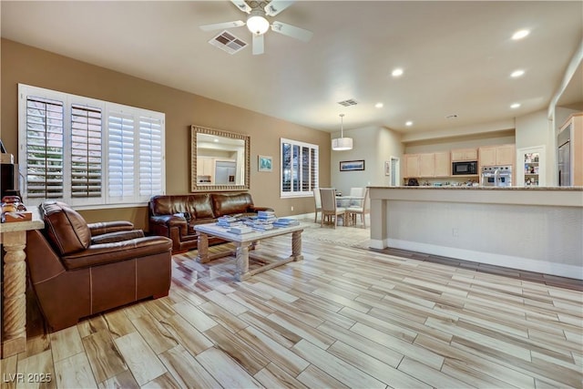 living area with a healthy amount of sunlight, wood tiled floor, visible vents, and recessed lighting