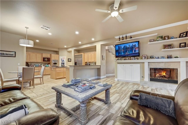 living area with visible vents, ceiling fan, a premium fireplace, wood tiled floor, and recessed lighting