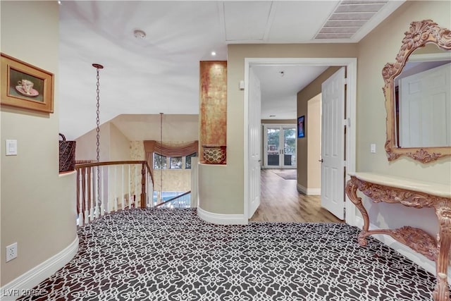 hallway with an upstairs landing, visible vents, and baseboards