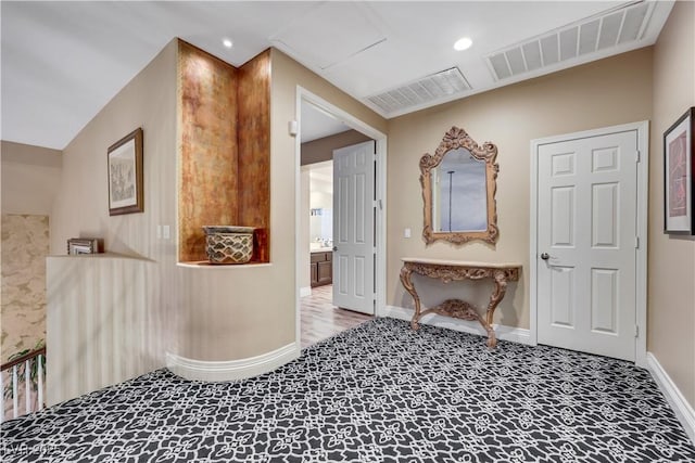 hallway featuring baseboards, visible vents, and recessed lighting