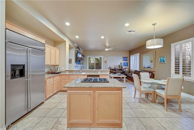 kitchen with built in fridge, a sink, visible vents, light brown cabinetry, and stovetop with downdraft