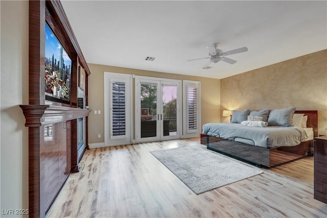 bedroom with visible vents, ceiling fan, wood finished floors, access to outside, and baseboards