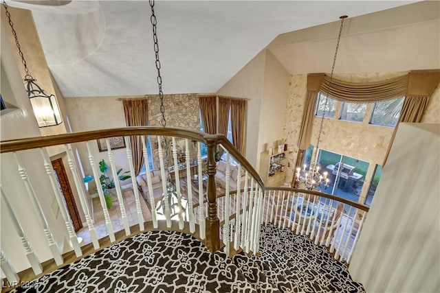 stairway with lofted ceiling and a notable chandelier