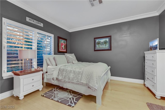 bedroom featuring light wood-type flooring, visible vents, crown molding, and baseboards