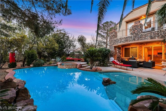 pool at dusk with a patio, an outdoor living space, and a pool with connected hot tub