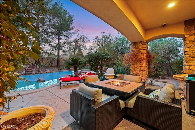 patio terrace at dusk with fence, an outdoor living space with a fire pit, and an outdoor pool