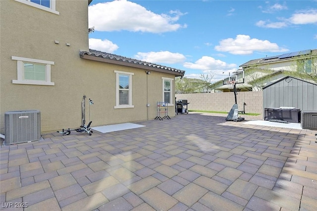 view of patio / terrace with central AC, grilling area, fence, and an outdoor structure