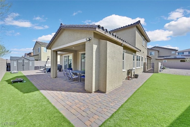 rear view of house featuring a patio, a fenced backyard, an outdoor structure, stucco siding, and a shed