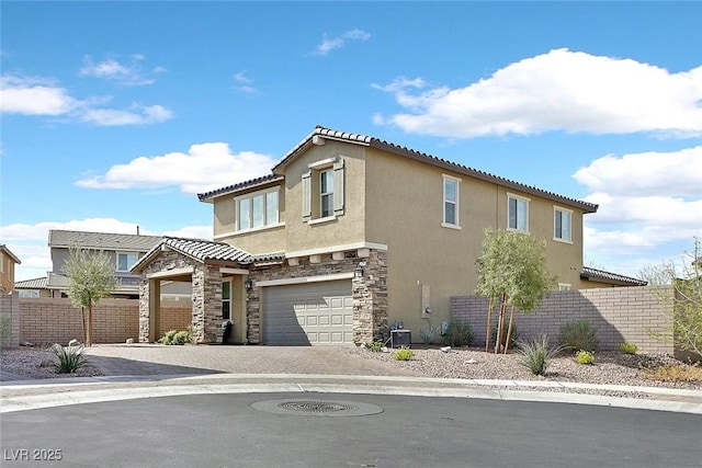 exterior space with decorative driveway, stucco siding, central AC unit, fence, and stone siding