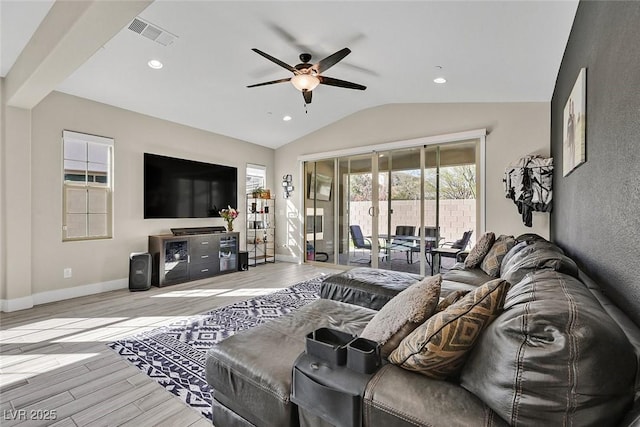 living room featuring lofted ceiling, ceiling fan, wood finished floors, visible vents, and baseboards