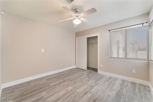 unfurnished bedroom featuring light wood finished floors, a closet, visible vents, and baseboards