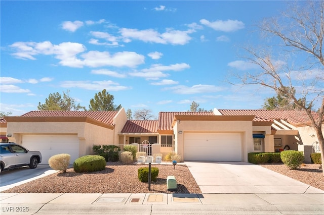 mediterranean / spanish-style home featuring a garage, driveway, and stucco siding