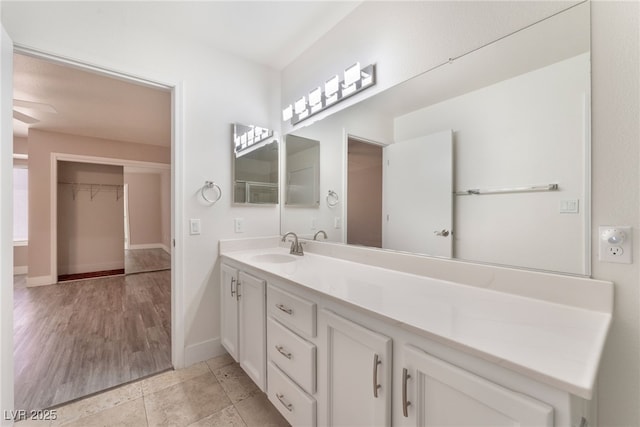 bathroom featuring vanity, baseboards, and tile patterned floors