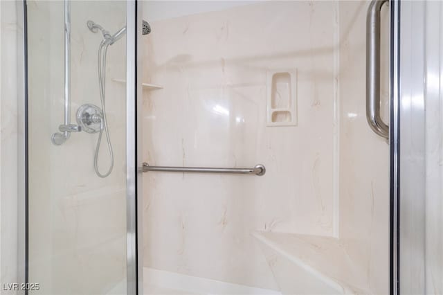 bathroom featuring a marble finish shower