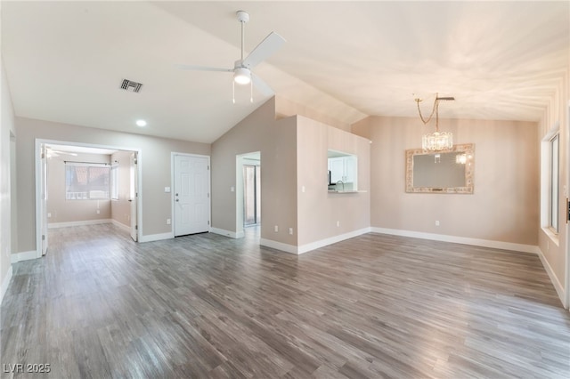 unfurnished living room featuring baseboards, visible vents, vaulted ceiling, and wood finished floors