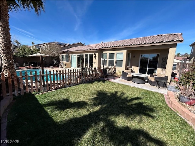 rear view of house with a fenced in pool, fence, a yard, a patio area, and stucco siding