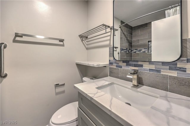 bathroom featuring tasteful backsplash, curtained shower, vanity, and toilet