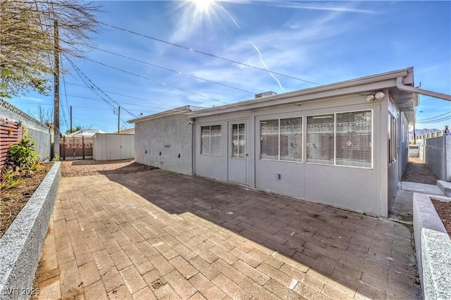 back of house featuring a patio area, a fenced backyard, and stucco siding