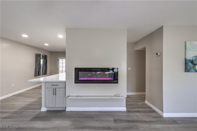 kitchen featuring light countertops, recessed lighting, wood finished floors, and baseboards