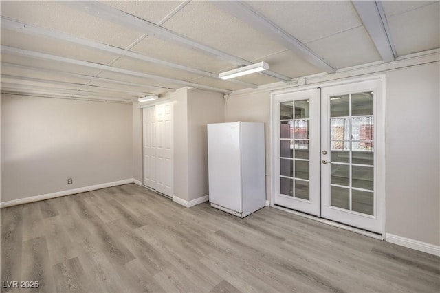 unfurnished room featuring baseboards, wood finished floors, and french doors