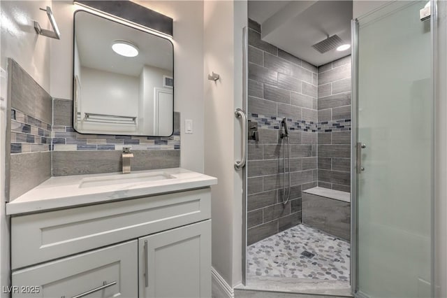 bathroom with a stall shower, backsplash, and vanity