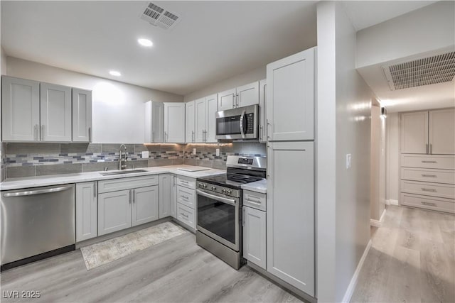 kitchen with visible vents, appliances with stainless steel finishes, tasteful backsplash, and a sink