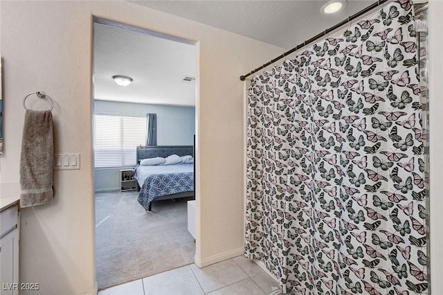 ensuite bathroom with visible vents, a shower with shower curtain, connected bathroom, vanity, and tile patterned floors