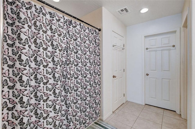 full bathroom with a shower with curtain, visible vents, and tile patterned floors