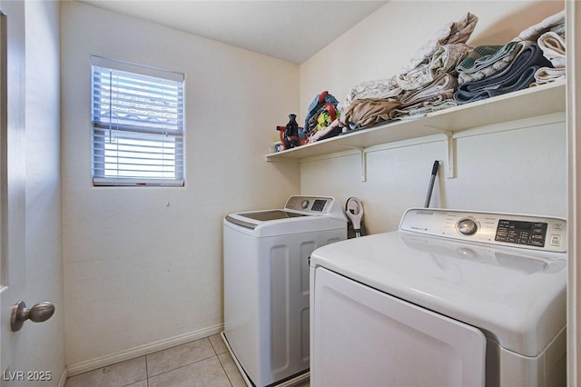 laundry area featuring laundry area, light tile patterned floors, baseboards, and independent washer and dryer