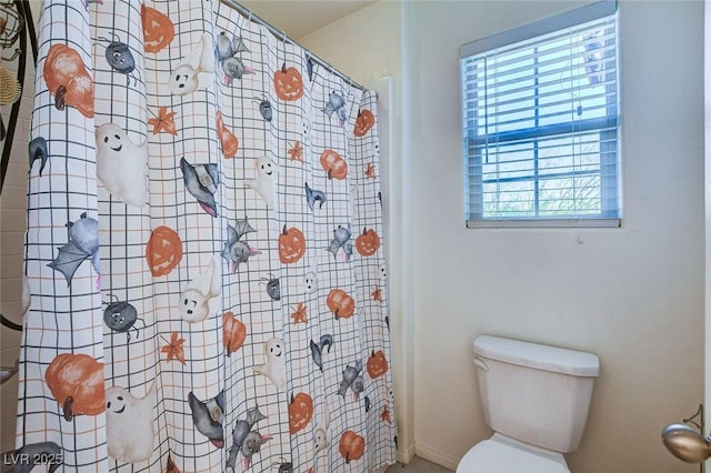 bathroom with a shower with curtain and toilet