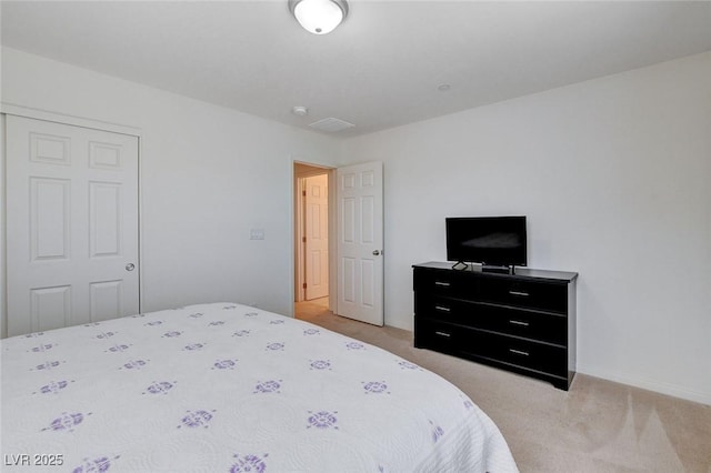 bedroom with a closet, light carpet, and baseboards