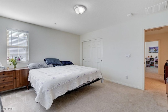 bedroom with light colored carpet, a closet, visible vents, and baseboards