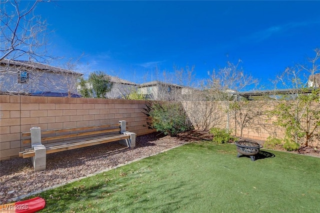 view of yard featuring an outdoor fire pit and a fenced backyard