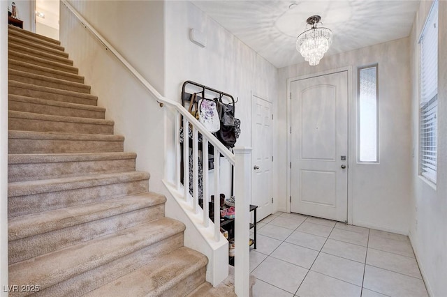 entryway with stairs, light tile patterned flooring, and a chandelier