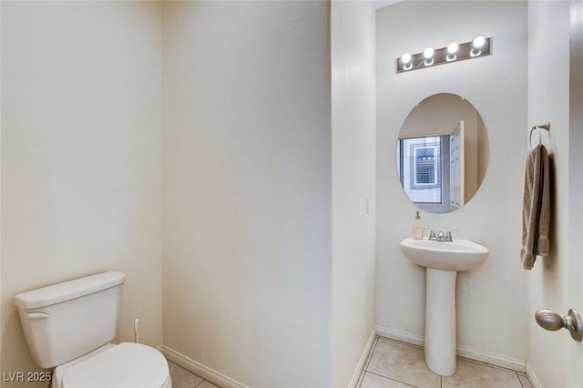 bathroom with baseboards, toilet, and tile patterned floors