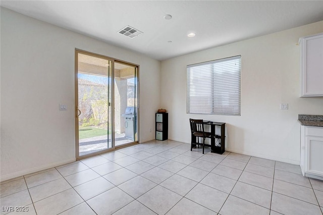 unfurnished dining area featuring light tile patterned floors, plenty of natural light, and visible vents