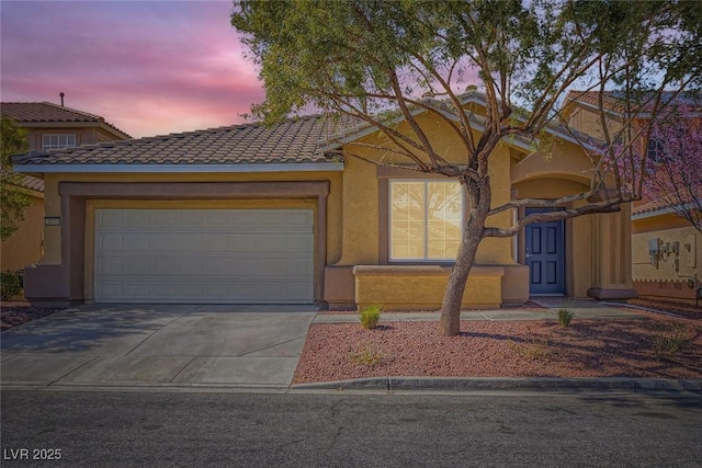 view of front of property featuring a garage, driveway, a tiled roof, and stucco siding