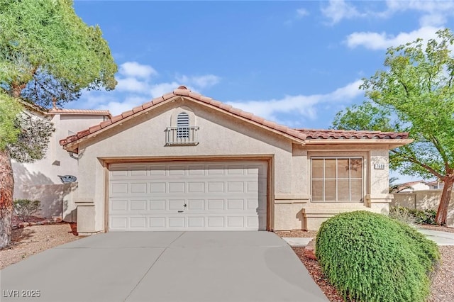 mediterranean / spanish-style home with an attached garage, driveway, a tile roof, and stucco siding