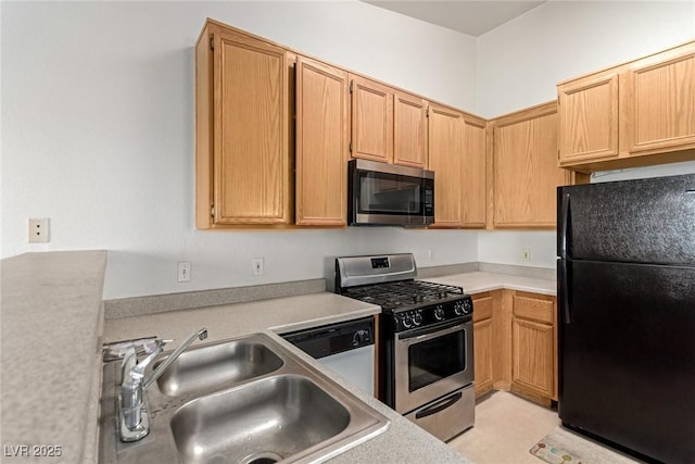 kitchen with light countertops, appliances with stainless steel finishes, and a sink