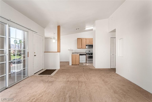 unfurnished living room featuring light carpet, ceiling fan, and lofted ceiling