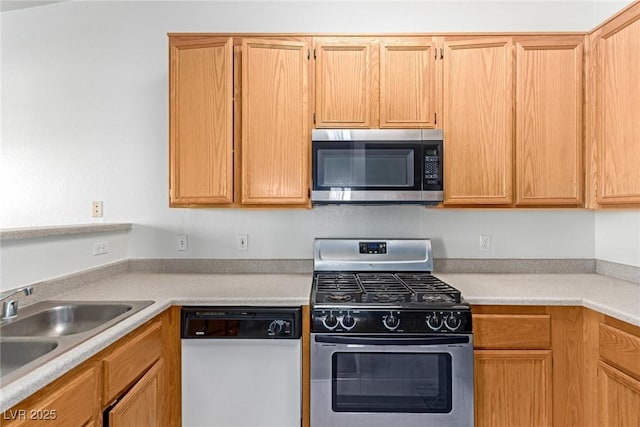 kitchen featuring light countertops, appliances with stainless steel finishes, and a sink