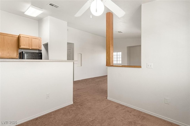 interior space featuring visible vents, a ceiling fan, lofted ceiling, freestanding refrigerator, and carpet