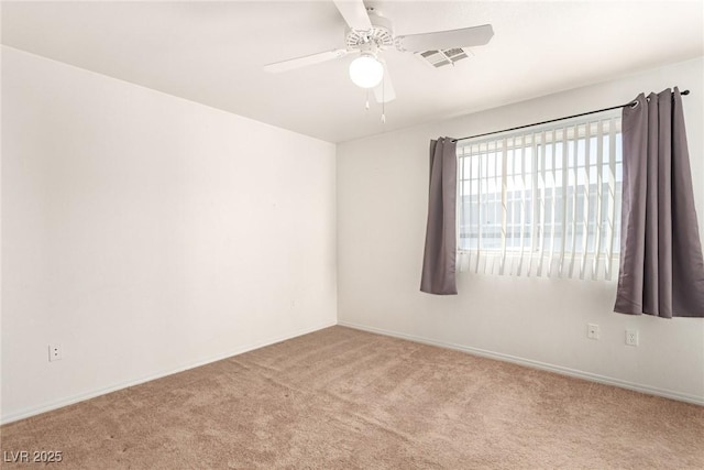 carpeted spare room with visible vents and ceiling fan