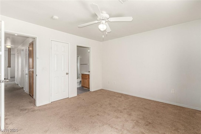 unfurnished bedroom with carpet floors, baseboards, ceiling fan, and ensuite bath