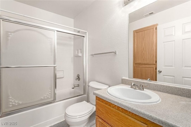 bathroom with visible vents, vanity, toilet, and combined bath / shower with glass door