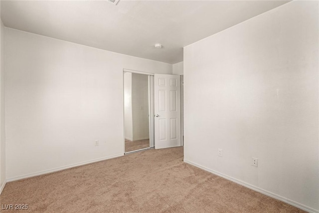 spare room with light colored carpet and baseboards