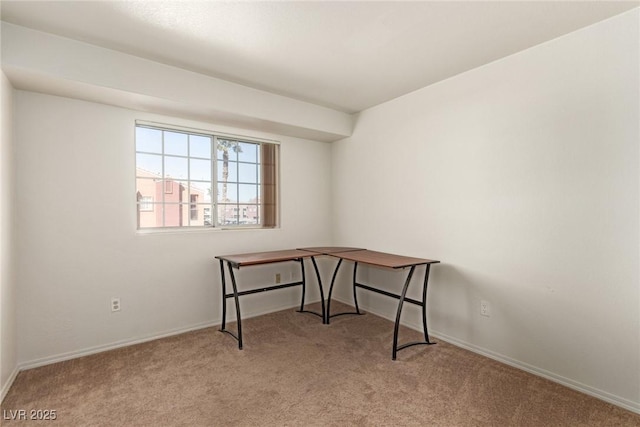 carpeted office space featuring baseboards