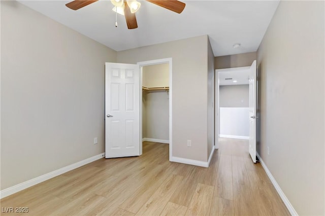 unfurnished bedroom featuring light wood-style floors, baseboards, and a closet